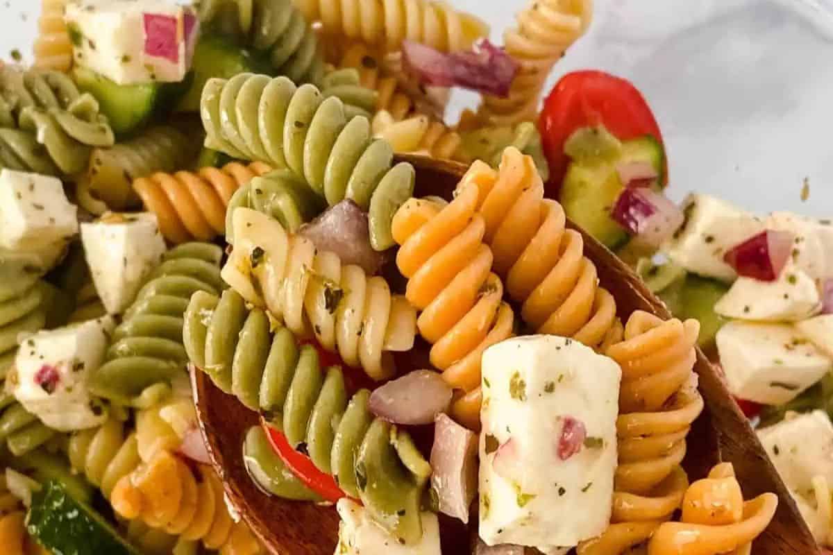A refreshing and colorful pasta salad made with tri-color rotini, diced cucumbers, cherry tomatoes, red onions, mozzarella cubes, and a zesty Italian dressing. A perfect dish for summer gatherings.