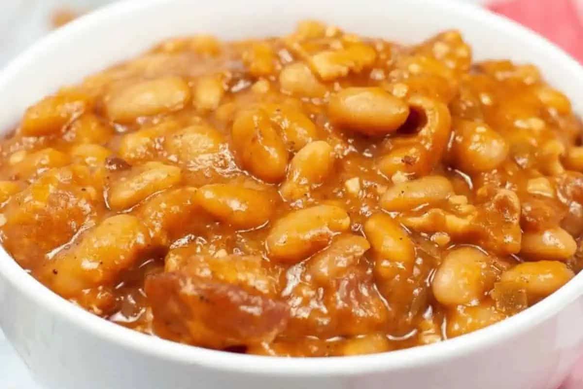 A white bowl filled with baked beans in a thick, reddish-brown sauce—perfect for repeat use and an ideal addition to your favorite Instant Pot recipes.
