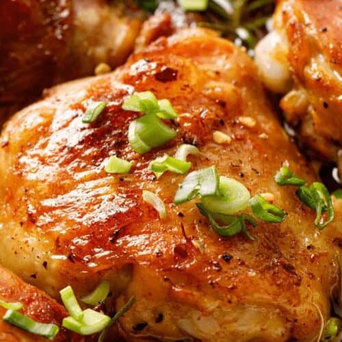 Close-up of browned, juicy chicken thighs garnished with chopped green onions—perfect for anyone seeking delicious chicken thigh recipes.