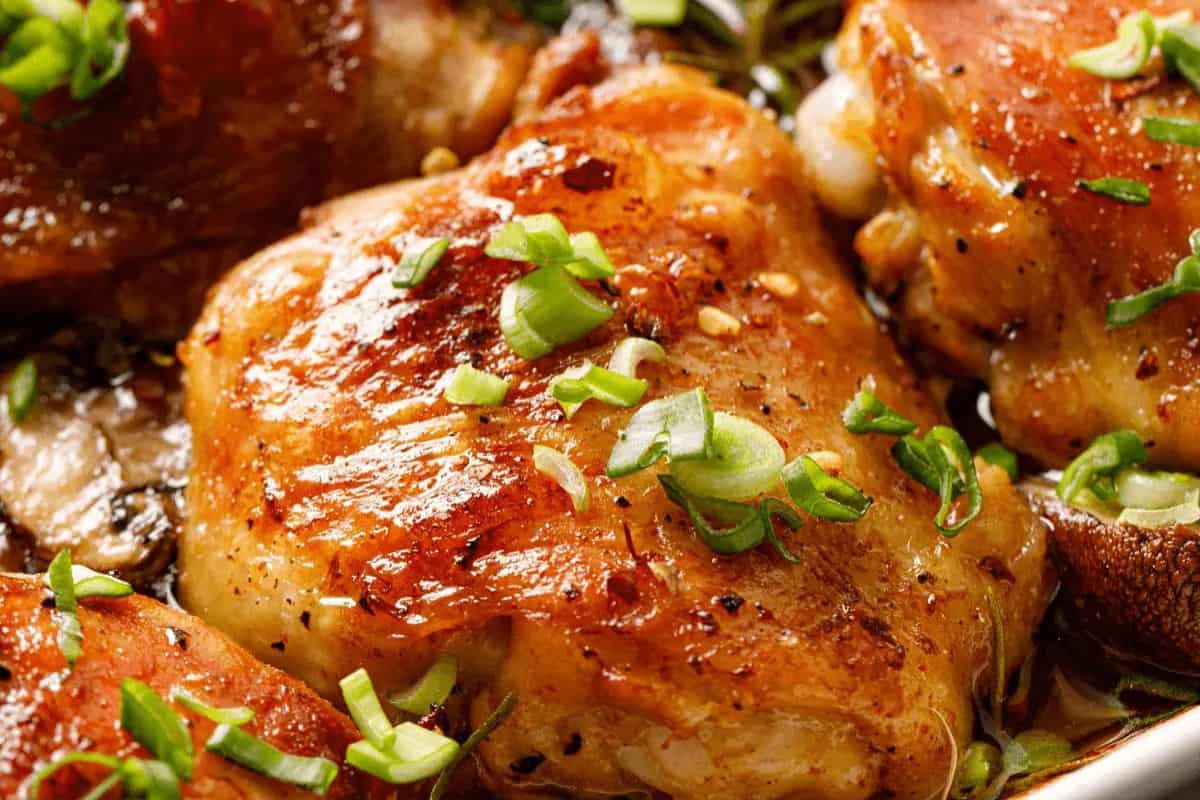 Close-up of browned, juicy chicken thighs garnished with chopped green onions—perfect for anyone seeking delicious chicken thigh recipes.