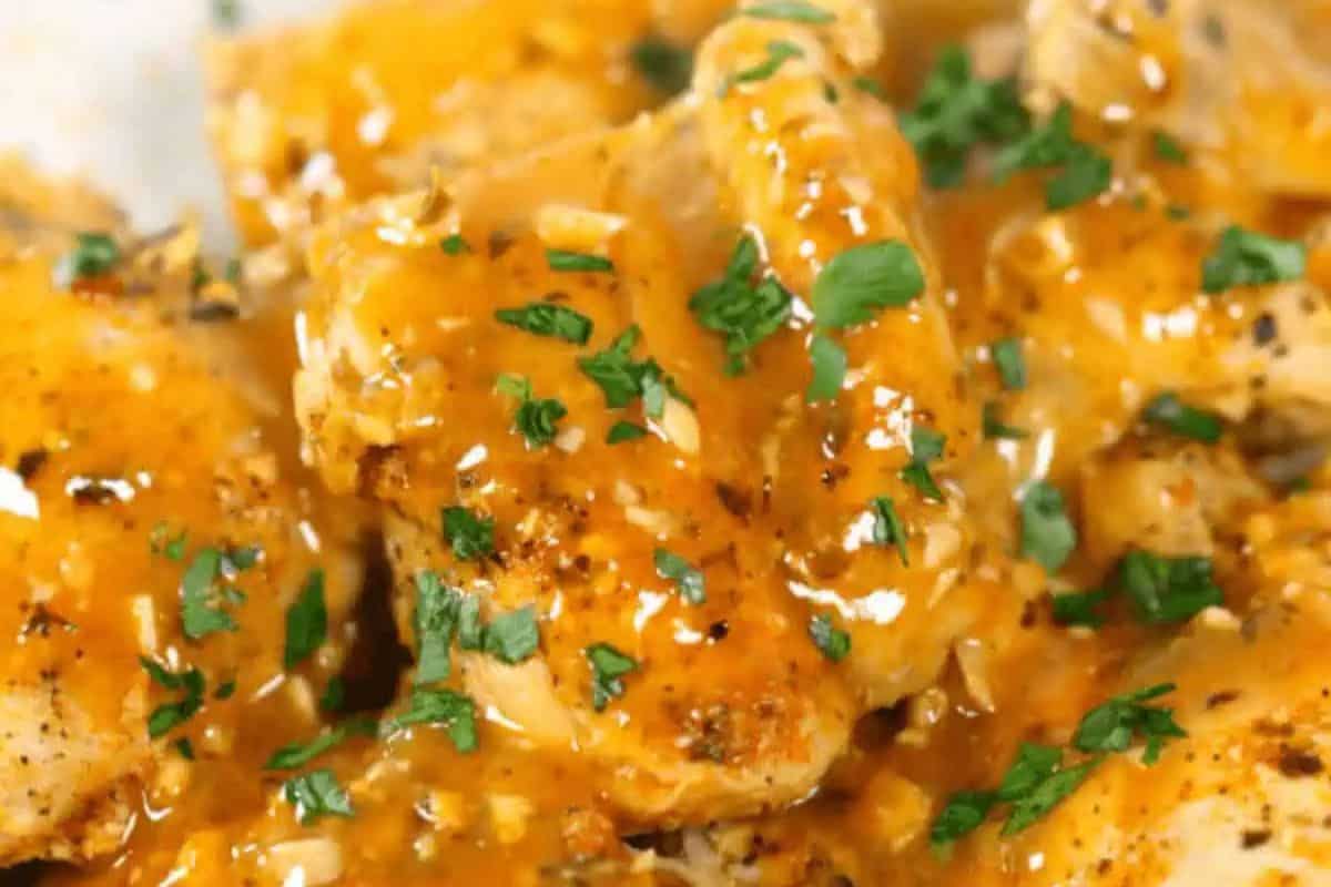 Close-up of juicy chicken thighs coated in peri peri sauce, garnished with chopped parsley—a delicious highlight for your favorite chicken recipes.