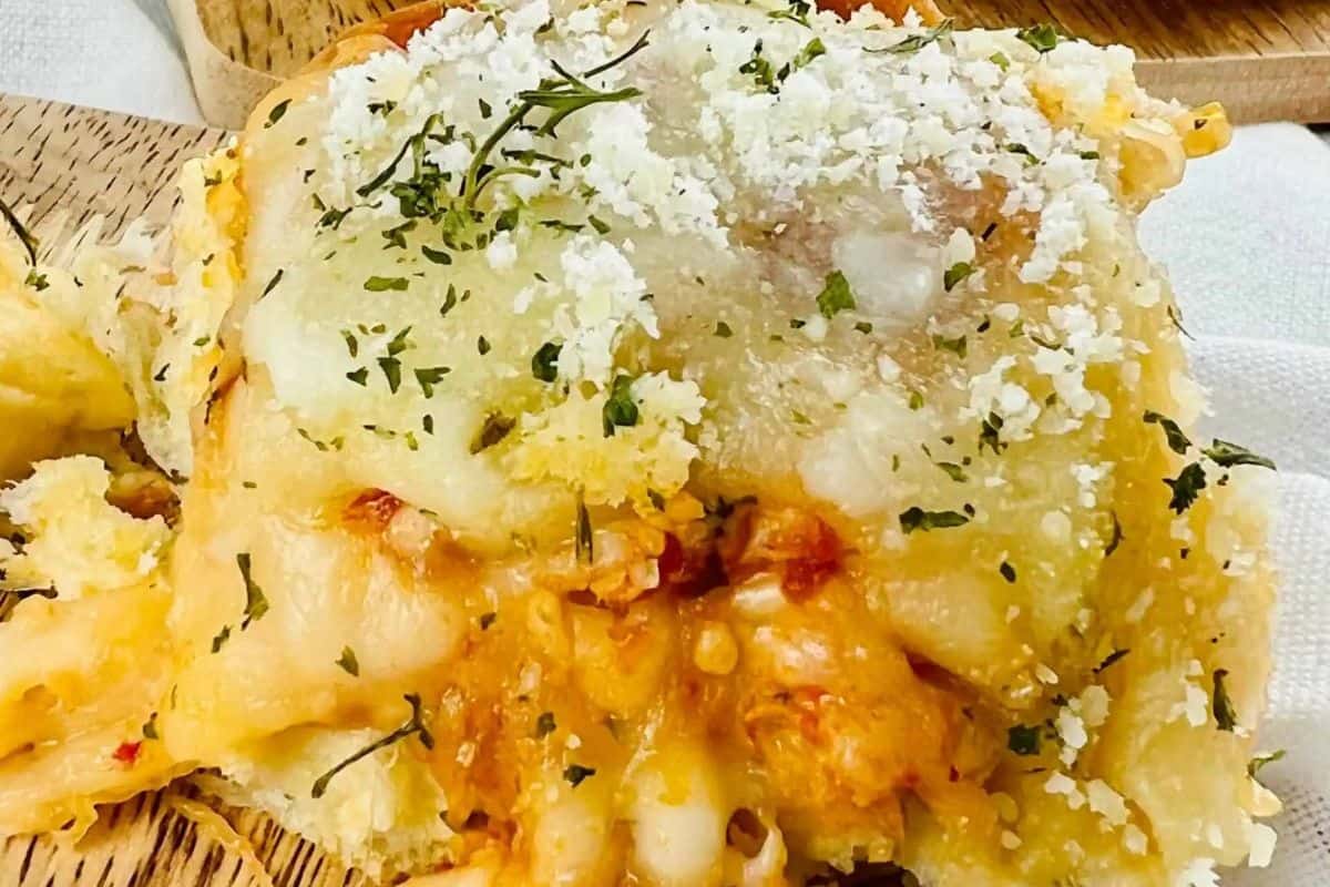 Close-up of a delicious dinner featuring a cheesy, baked dish topped with fresh herbs and grated cheese on a wooden plate, perfect for your easy dinner ideas.