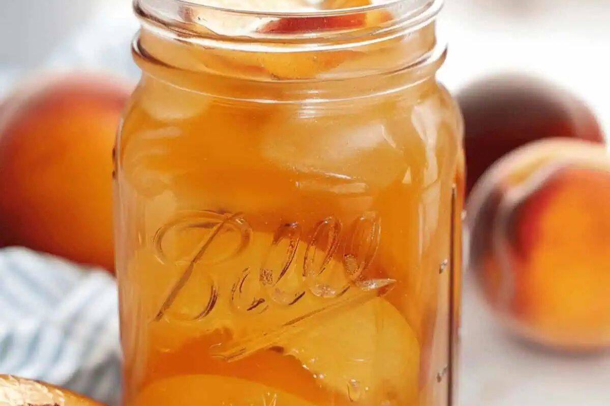 Peach Moonshine featuring sliced peaches infused in a clear spirit.