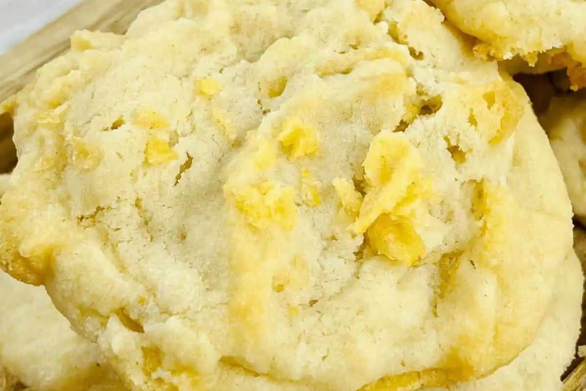 A close-up of a crumbly, golden-brown cookie with visible chunks of potato chips on its surface, reminiscent of classic recipes found in vintage dishes.