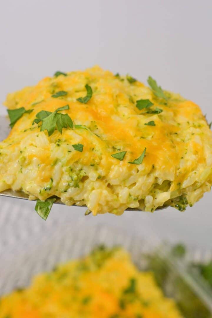 A close-up of a serving of velveeta broccoli rice casserole topped with chopped parsley.