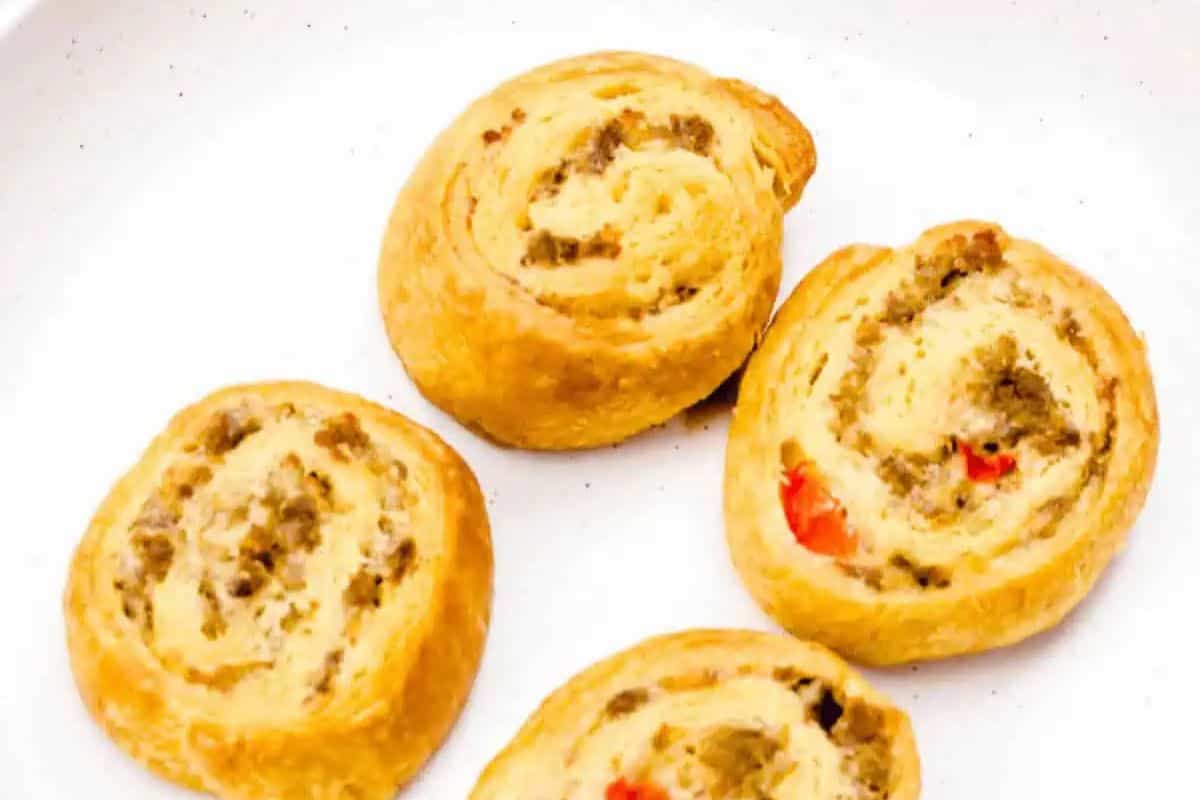 These golden, spiral-shaped pinwheels are made with flaky crescent roll dough and filled with a savory sausage mixture. A hint of red pepper adds a pop of color and mild sweetness. They’re perfect for a quick snack, appetizer, or brunch bite.
