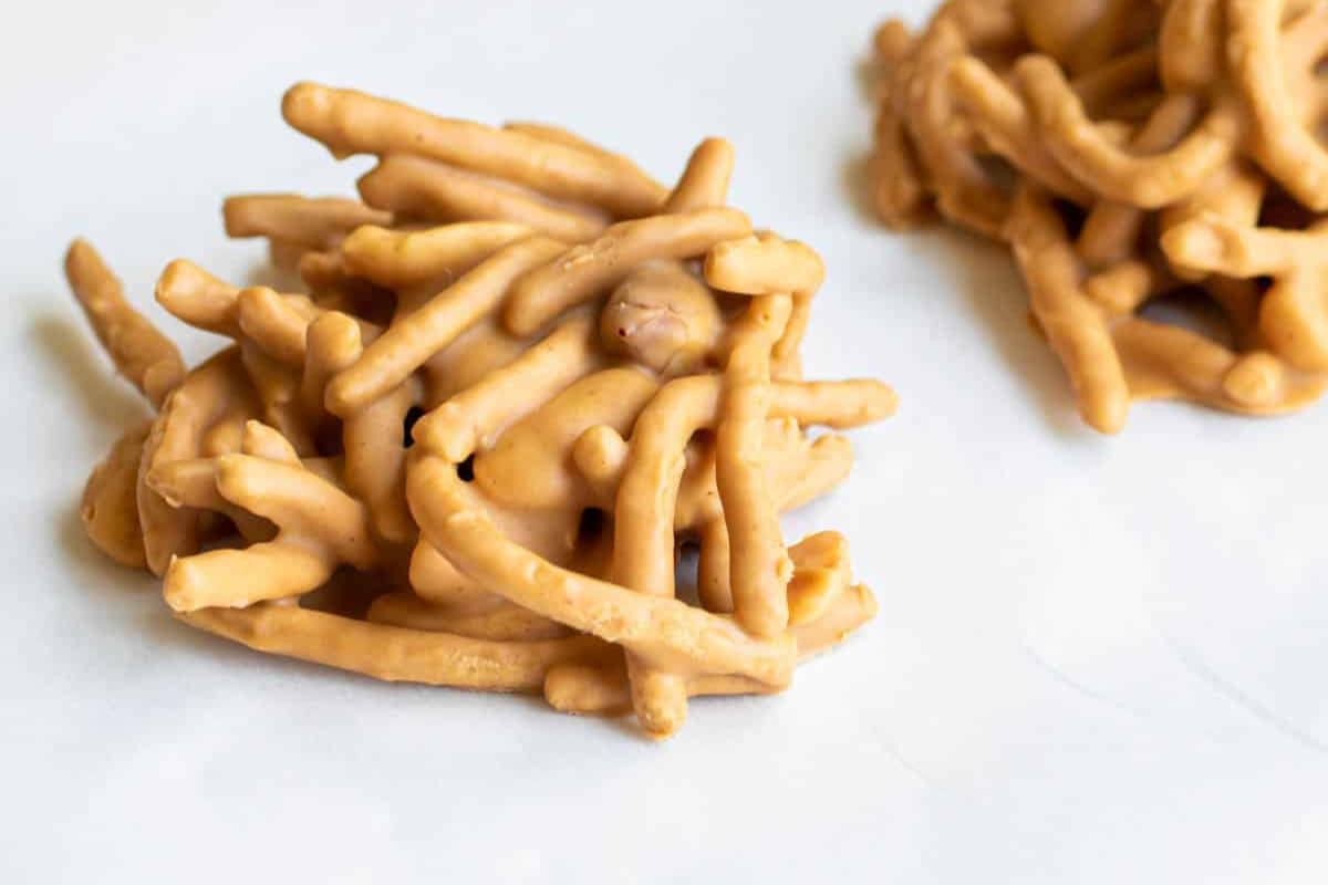 A cluster of coated, crunchy noodles stacked on a light surface, reminiscent of rich butterscotch flavors.