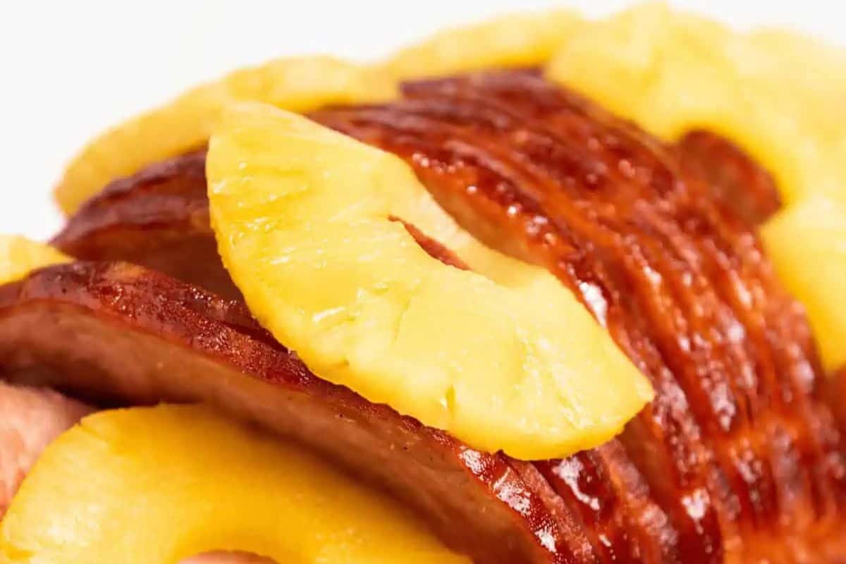 Juicy spiral-cut ham is layered with slices of sweet pineapple in this vibrant close-up. The ham’s glistening glaze and golden edges promise rich, tender flavor in every bite. It’s a simple, sunny, and satisfying dish that speaks to convenience and taste.