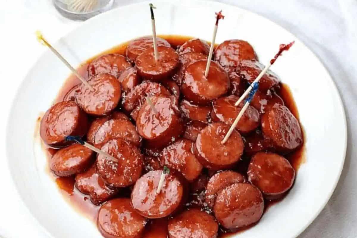 Slices of sausage are coated in a glossy, sweet-and-spicy glaze and served with toothpicks for easy snacking. This slow cooker appetizer is a crowd-pleasing option for parties, potlucks, or game day.