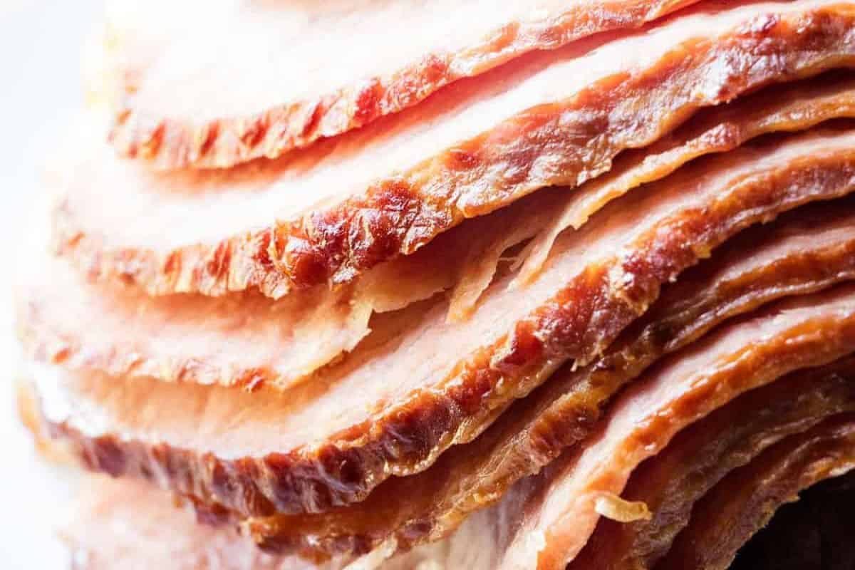 Close-up view of several slices of cooked, glazed ham stacked together—perfect for classic ham recipes and holiday recipes.