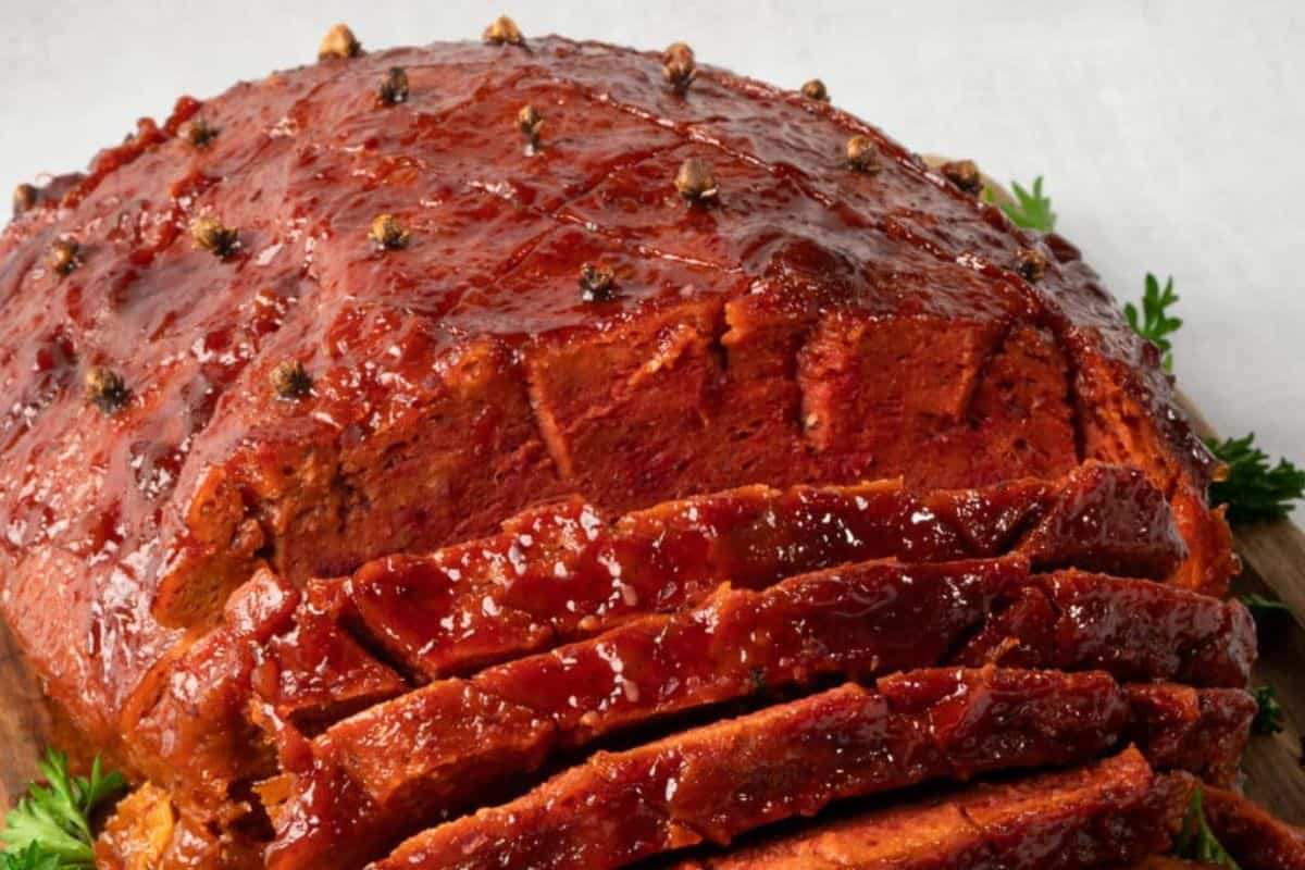 This vibrant Vegan Ham looks just as festive as the traditional version, with a thick, shiny glaze and whole cloves embedded on top. Sliced and fanned out, the texture looks tender and packed with flavor. It’s a plant-based beauty that brings everyone to the table.