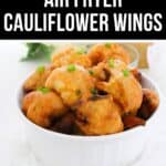 A white bowl filled with crispy Air Fryer Cauliflower Wings, garnished with chopped green onions, sits on a white surface.