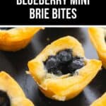 Close-up of several golden Mini Brie Bites pastry cups filled with blueberries and melted brie cheese on a dark surface.