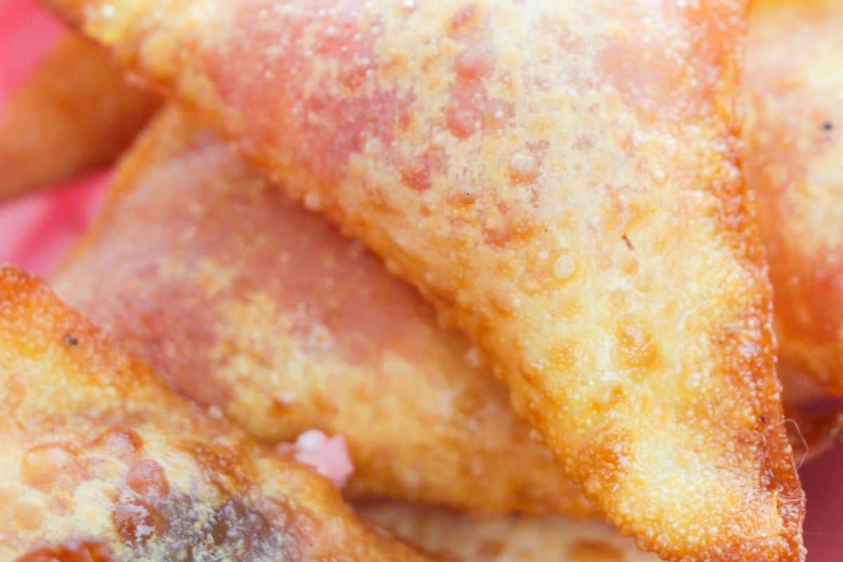 Close-up of several golden-brown, crispy fried samosas with visible bubbles on the surface—a savory snack that pairs perfectly with fresh cherry recipes for a delightful twist.