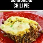 A serving of chili pie on a red plate, featuring a hearty layer of chili with beans and ground meat, all topped with golden baked cornbread.