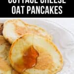 A close-up of Cottage Cheese Oat Pancakes on a white plate, with golden syrup being poured over the fluffy stack.