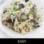 A plate of Creamy Mushroom Risotto, garnished with chopped parsley and grated cheese, is beautifully served on a white plate.