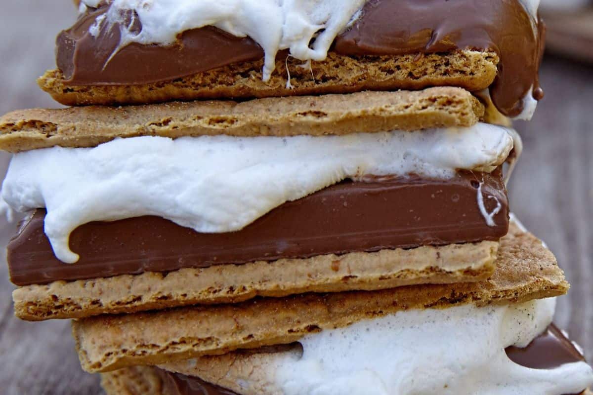 A close-up of flavor-packed s'mores showing layers of graham crackers, melted chocolate and toasted marshmallows—perfect for any camping trip.