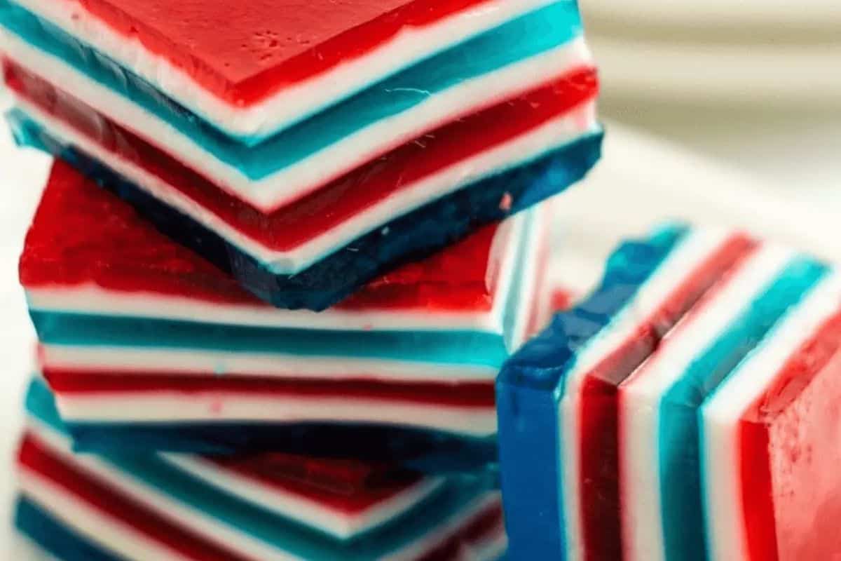 Close-up of stacked layered gelatin dessert squares in red, white, and blue colors—perfect Patriotic Party Foods for Memorial Day or Labor Day celebrations.