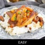 A plated dish of pineapple pork chops served over white rice, garnished with parsley, with a fresh pineapple and a pot in the background.