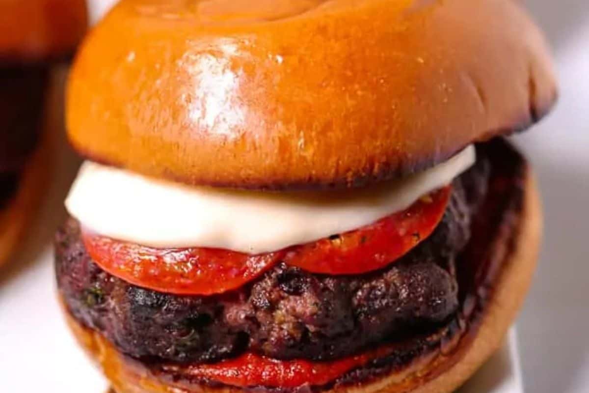 A hamburger with a beef patty, slices of pepperoni, melted cheese, and a toasted bun—a true taste of BBQ inspired by classic American recipes.