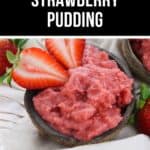 A bowl of strawberry pudding, topped with fresh sliced strawberries, sits on a white cloth, while whole strawberries add a vibrant touch in the background.