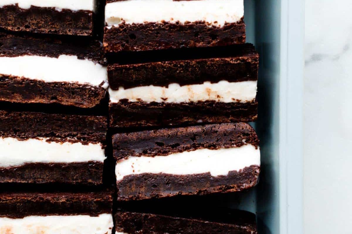 Rows of chocolate brownie ice cream sandwiches, each with a layer of vanilla ice cream between two layers of brownie—one of those wow desserts that's perfect for your summer dessert recipes collection.