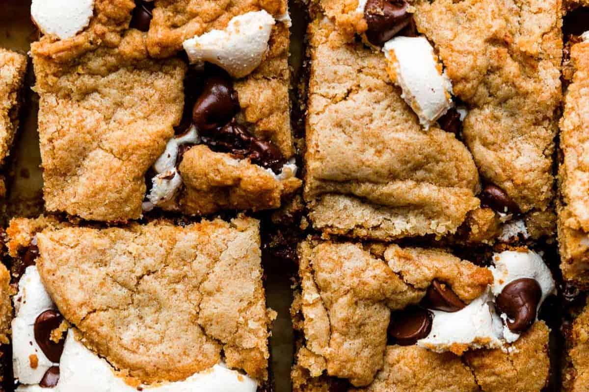 Close-up of baked dessert bars with golden-brown crust, chocolate chips, and visible melted marshmallows—one of our top Wow Desserts and a must-try for your collection of easy dessert recipes.