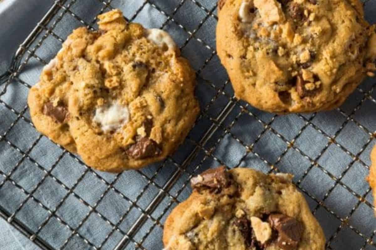 Flavor-packed chocolate chip cookies with chunks, resting on a wire cooling rack over a blue cloth.