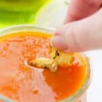 Dipping the snack into sauce.