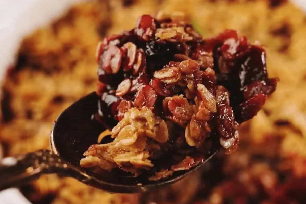 Close-up image of a spoonful of apple blueberry crisp. 