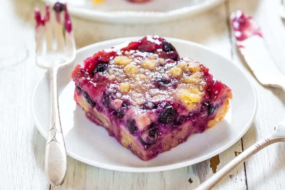 Close-up of a blueberry pie bar, served on a white plate.