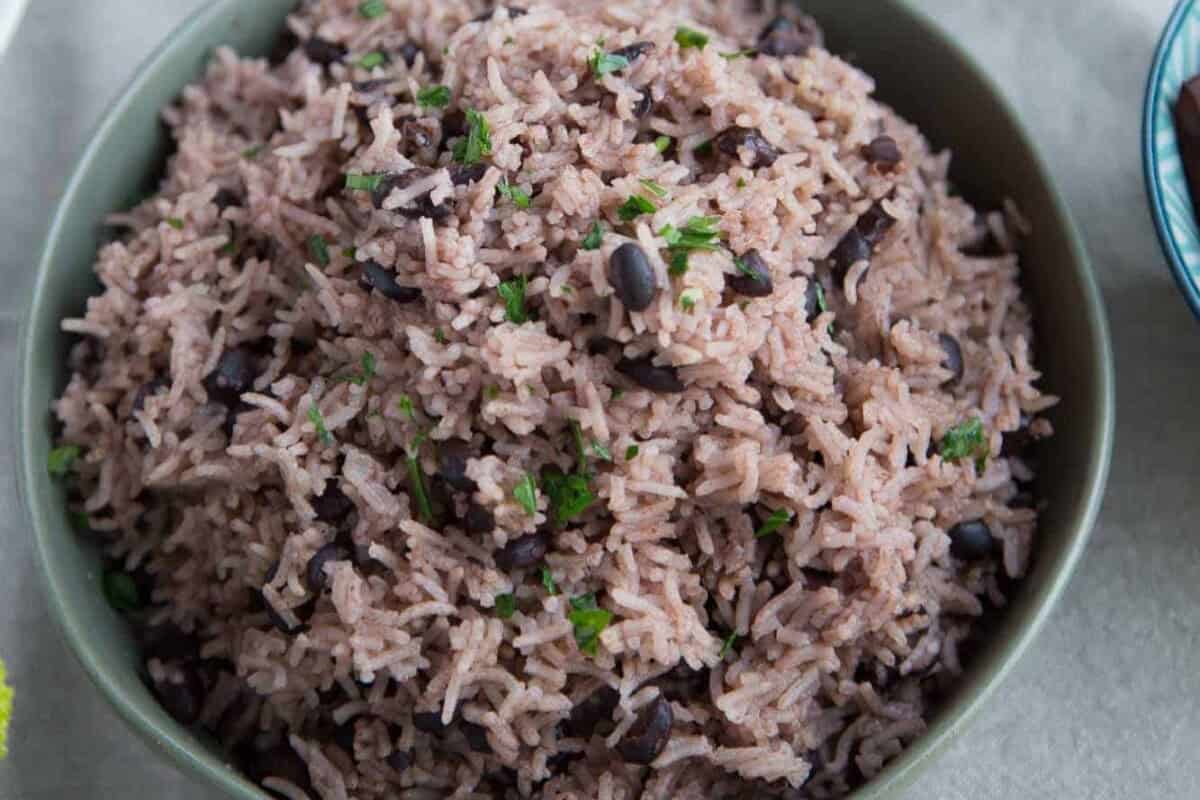 A bowl of cooked rice mixed with black beans and garnished with chopped herbs, this classic showcases the flavors of Cuban cuisine.
