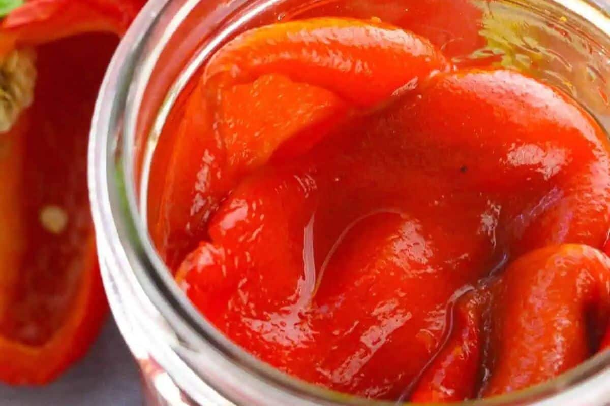 Close-up of some roasted red bell peppers in a jar.