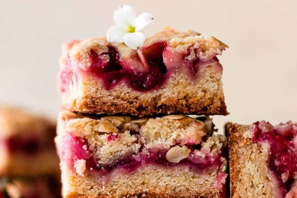 Delicious strawberry rhubarb crumb bars topped with a decorative flower.