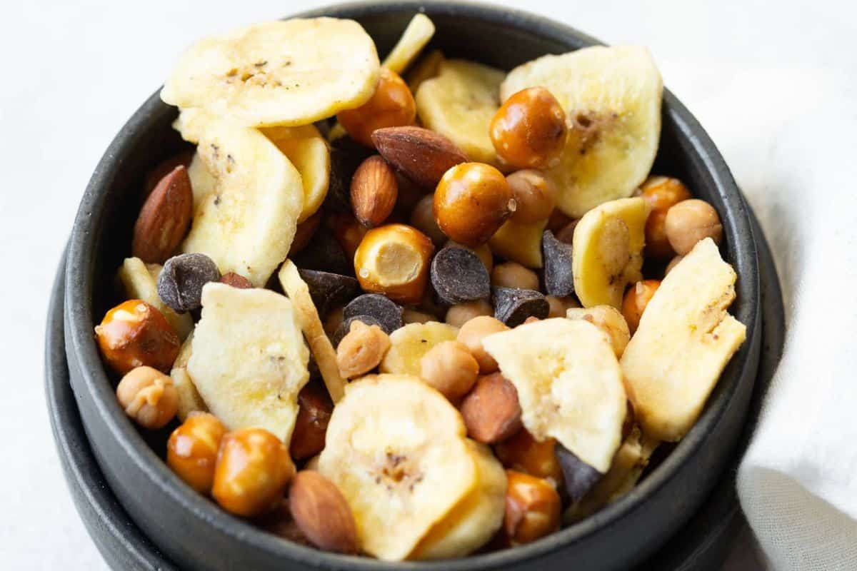 Mix of of banana chips, chocolate, caramel popcorn, and nuts for treat-worthy snack mix.