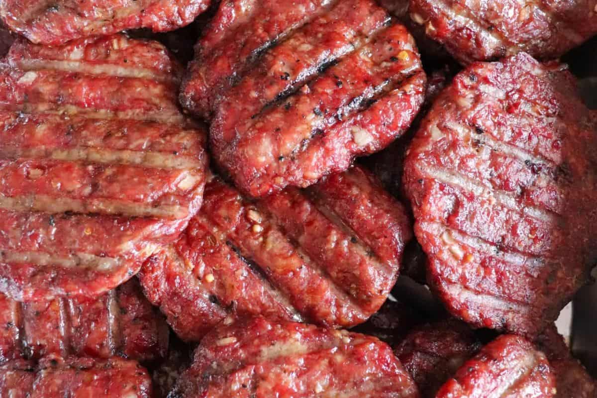 Smoked burger patties with visible smoke lines.