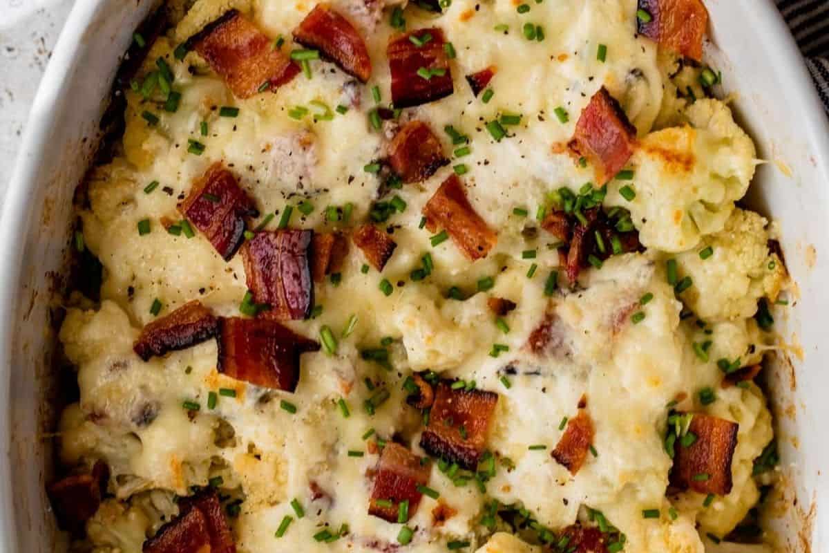 A flavor-packed baked casserole topped with melted cheese, chopped crispy bacon, and sprinkled chives.