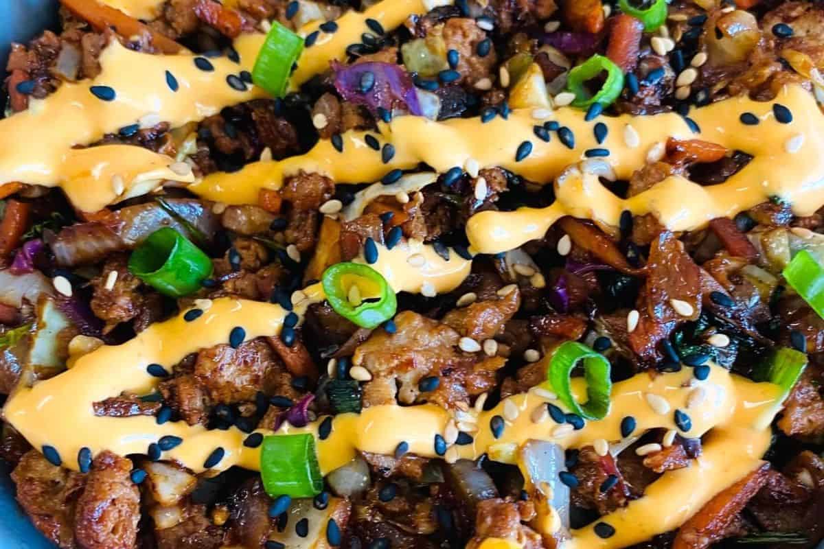 Egg roll in a bowl filled with seasoned pork, cabbage, and savory stir-fry sauce.