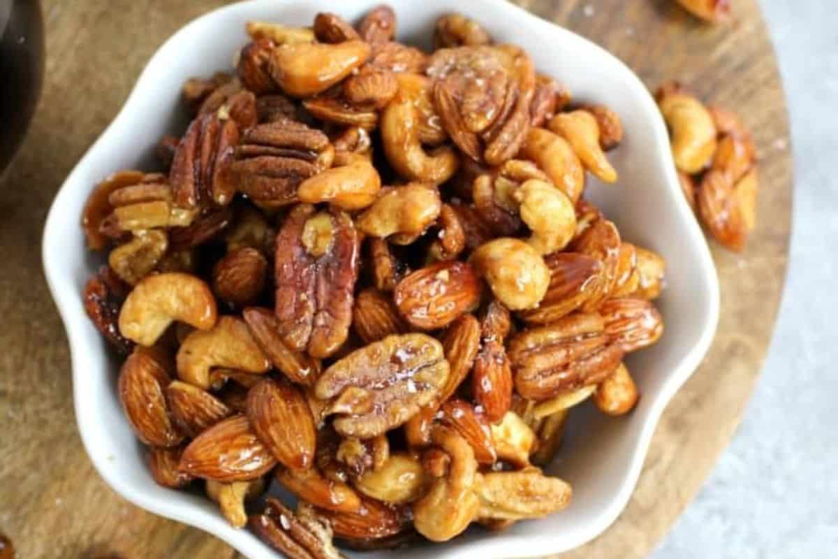 Close-up of honey roasted mixed nuts including almonds, cashews, and peanuts coated in a glossy, golden honey glaze.