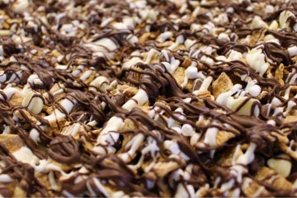 S'mores snack mix with graham crackers, mini marshmallows, and chocolate pieces combined for a sweet and crunchy treat.