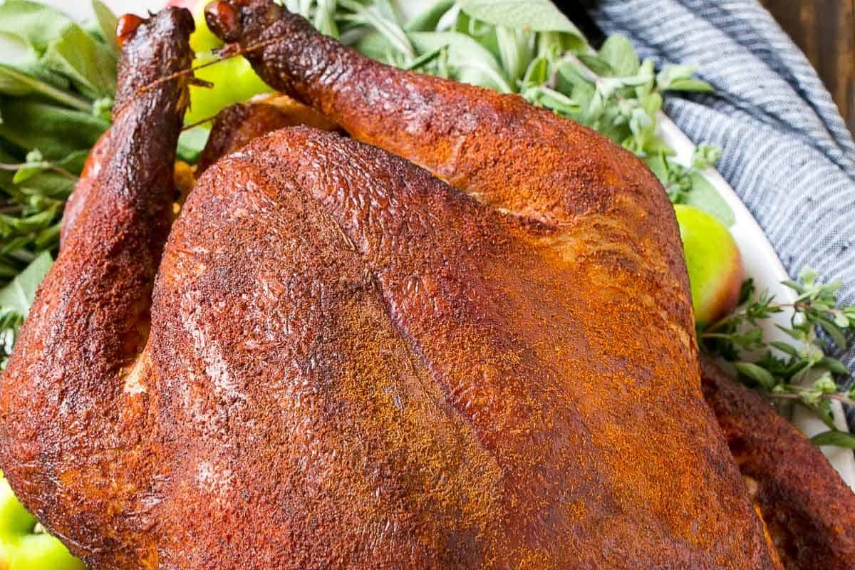 A whole smoked turkey with golden-brown, crispy skin and a rich smoky aroma.