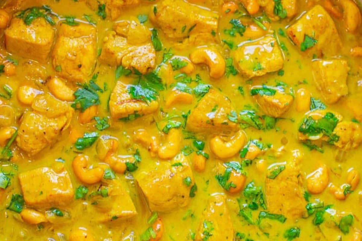 Chunks of meat cooked in a yellow curry sauce with cashews and chopped cilantro—a must try for fans of Indian recipes and bold flavors.
