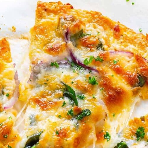 Close-up of cheesy pizza slices topped with red onions, green herbs, and melted cheese—an ideal option for cheap meals and budget friendly dinners.