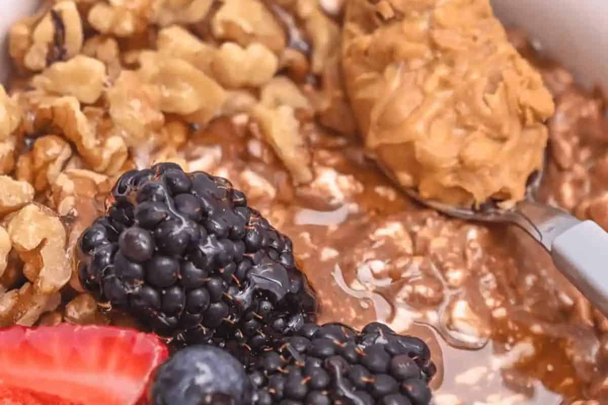 Close-up of a chocolate cottage cheese breakfast bowl, topped with blackberries, strawberries, and blueberries.
