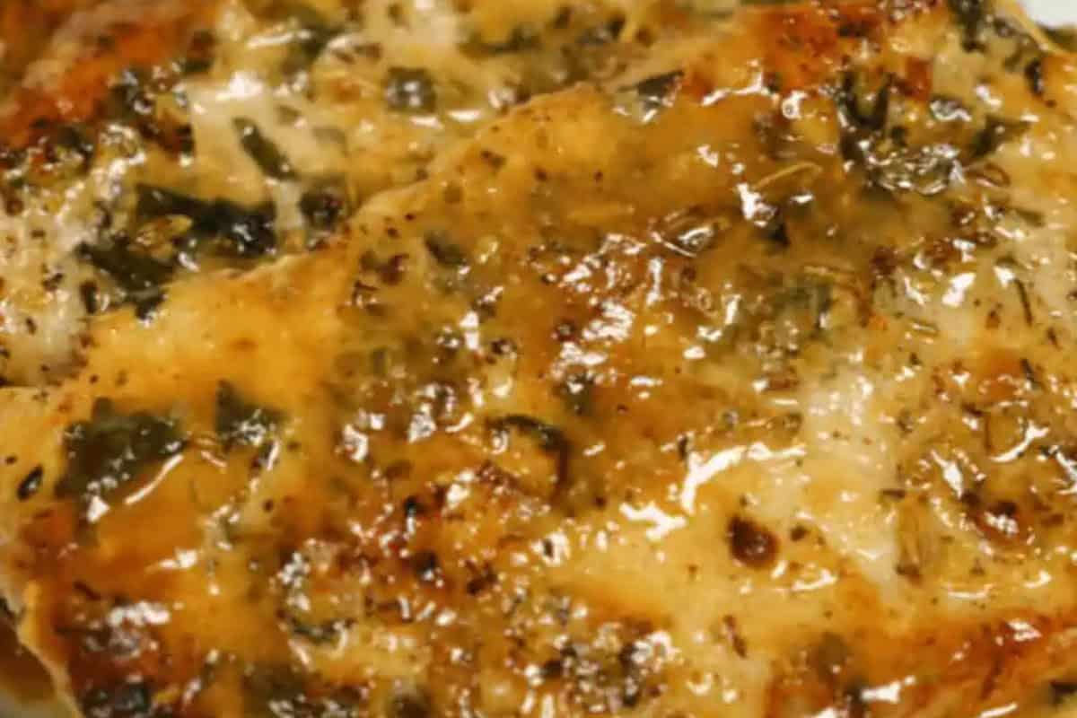 Close-up of a cooked, seasoned chicken breast with a glossy herb and spice coating, inspired by classic Italian recipes.