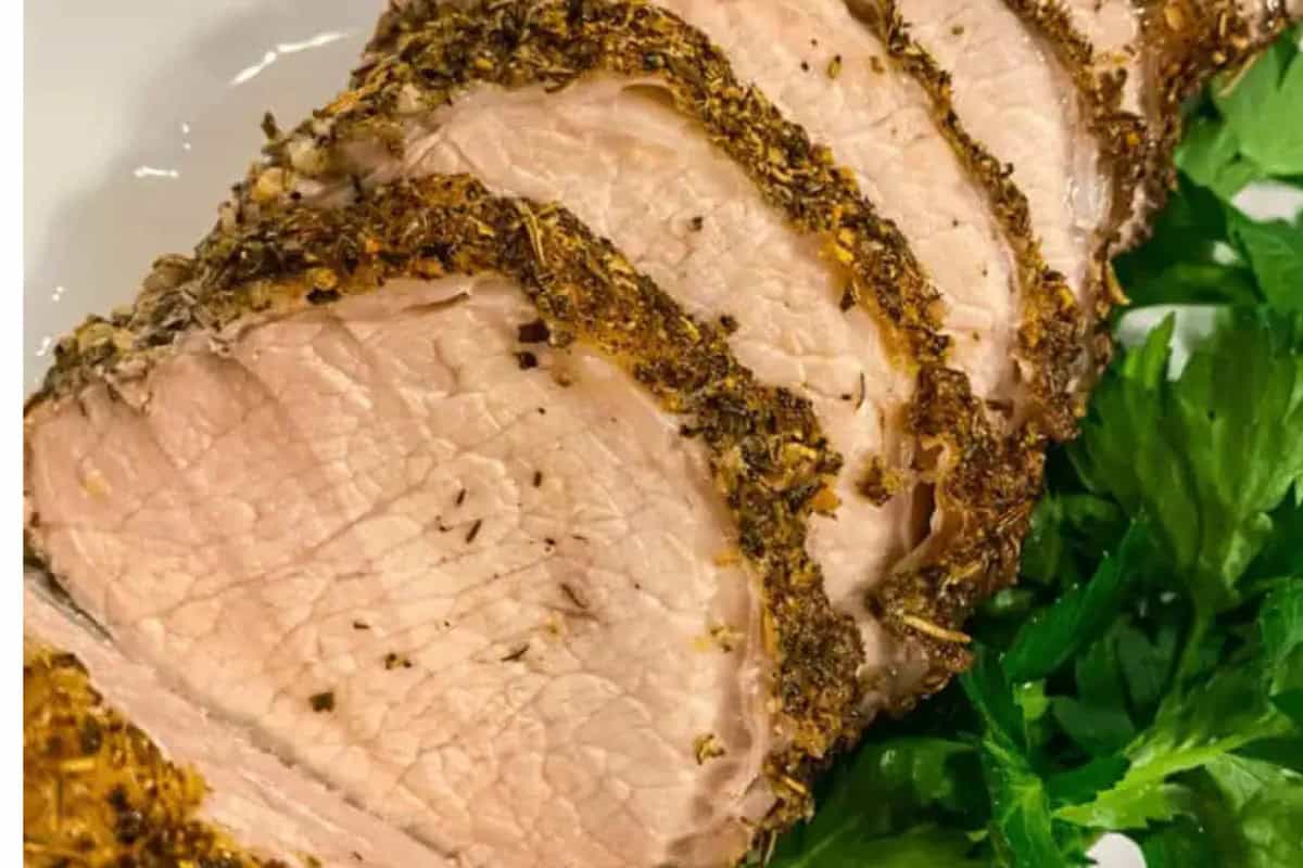Sliced herb-crusted pork tenderloin arranged on a plate with fresh parsley garnish, inspired by classic Italian recipes.