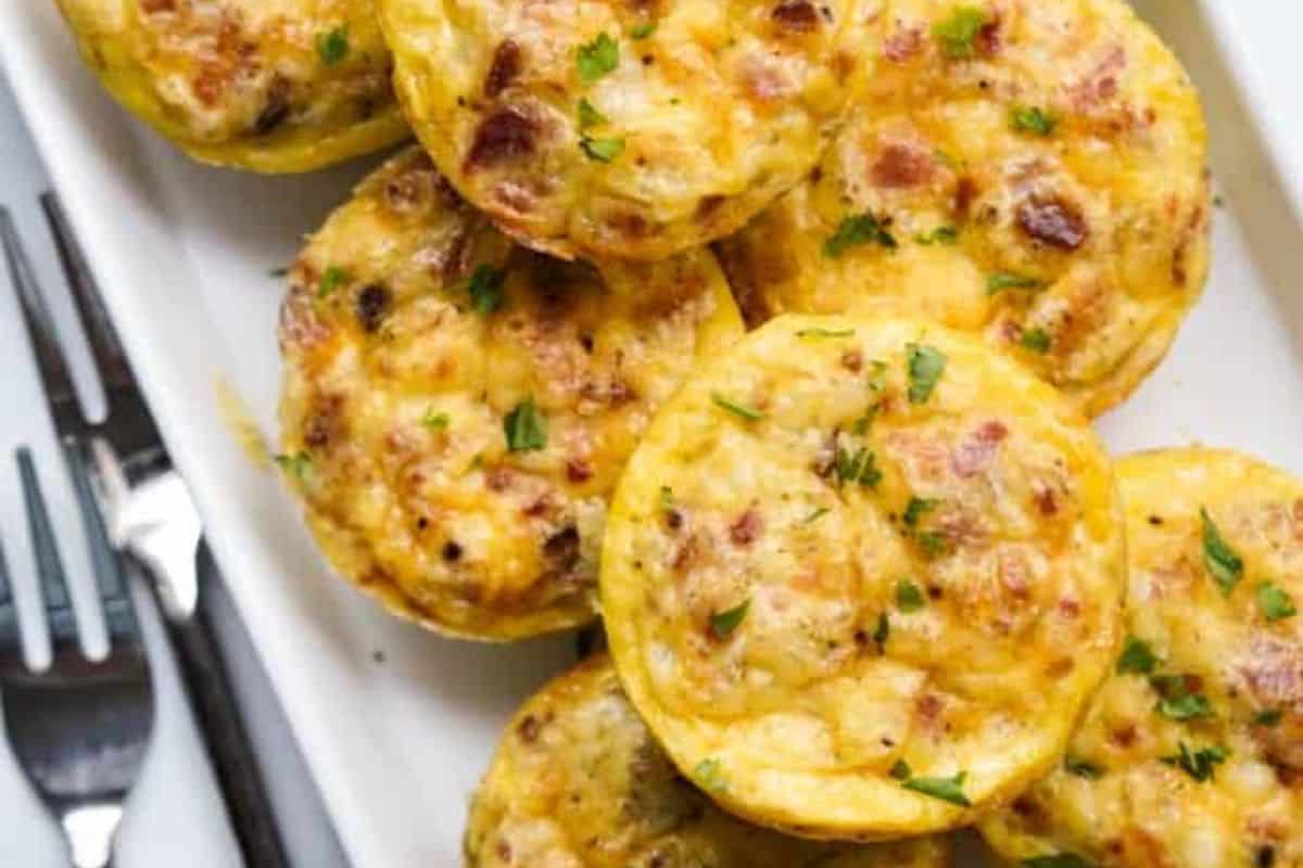 Close-up of some cottage cheese egg bites, served on a white tray with forks on the side.