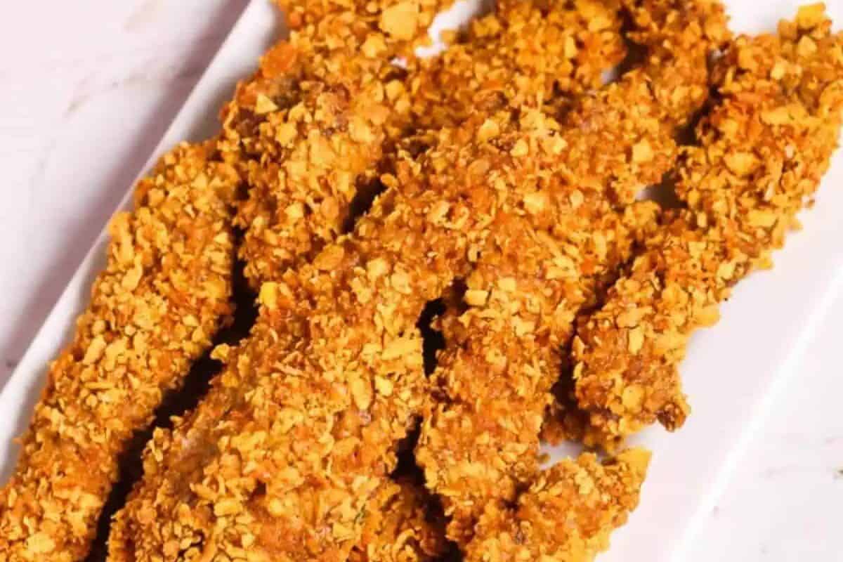 Five breaded and baked steak tenders arranged in parallel on a white rectangular plate, offering a steakhouse-inspired twist to classic comfort food.