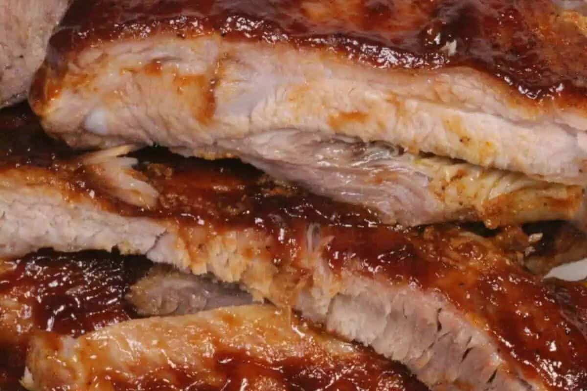 Close-up of some instant pot baby back ribs, coated in a BBQ sauce.